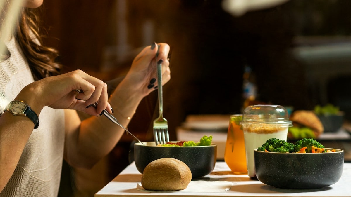 Women eating tasty chicken salad with dessert
