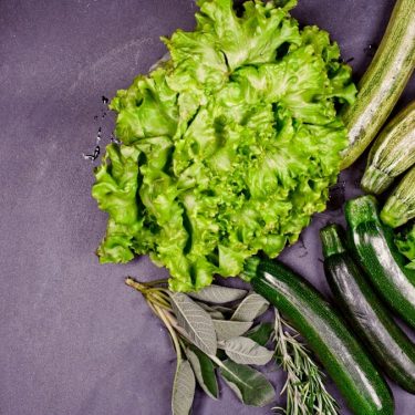 A group of vegetables sitting on top of a purple surface